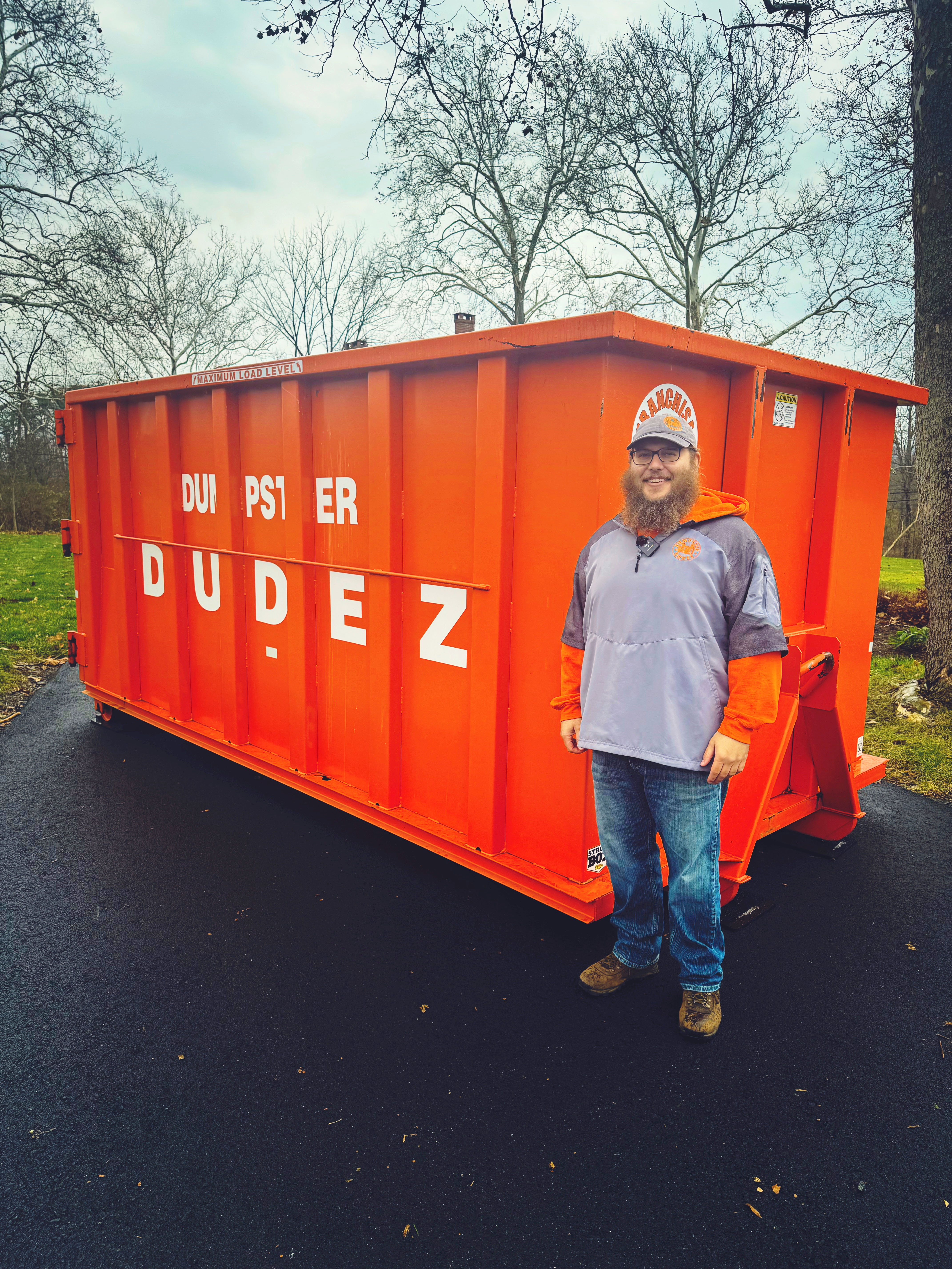 A Dumpster Dudez team member standing next to a 25 yard dumpster in Waco, TX.