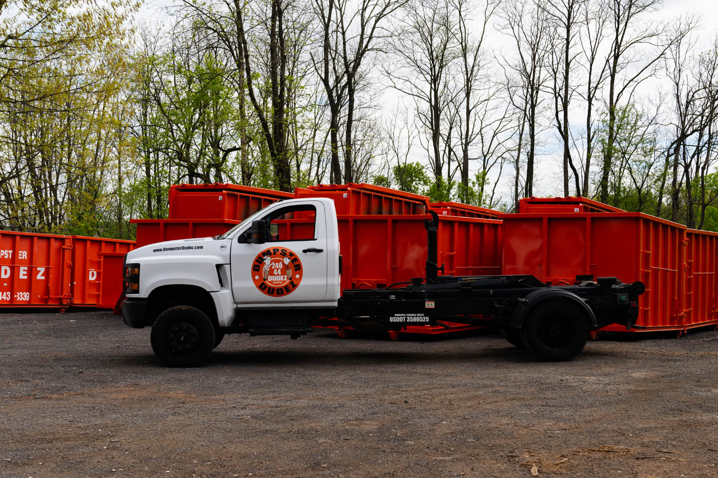 A Dumpster Dudez of Fort Worth truck parked in front of a variety of dumpster for estate cleanouts.