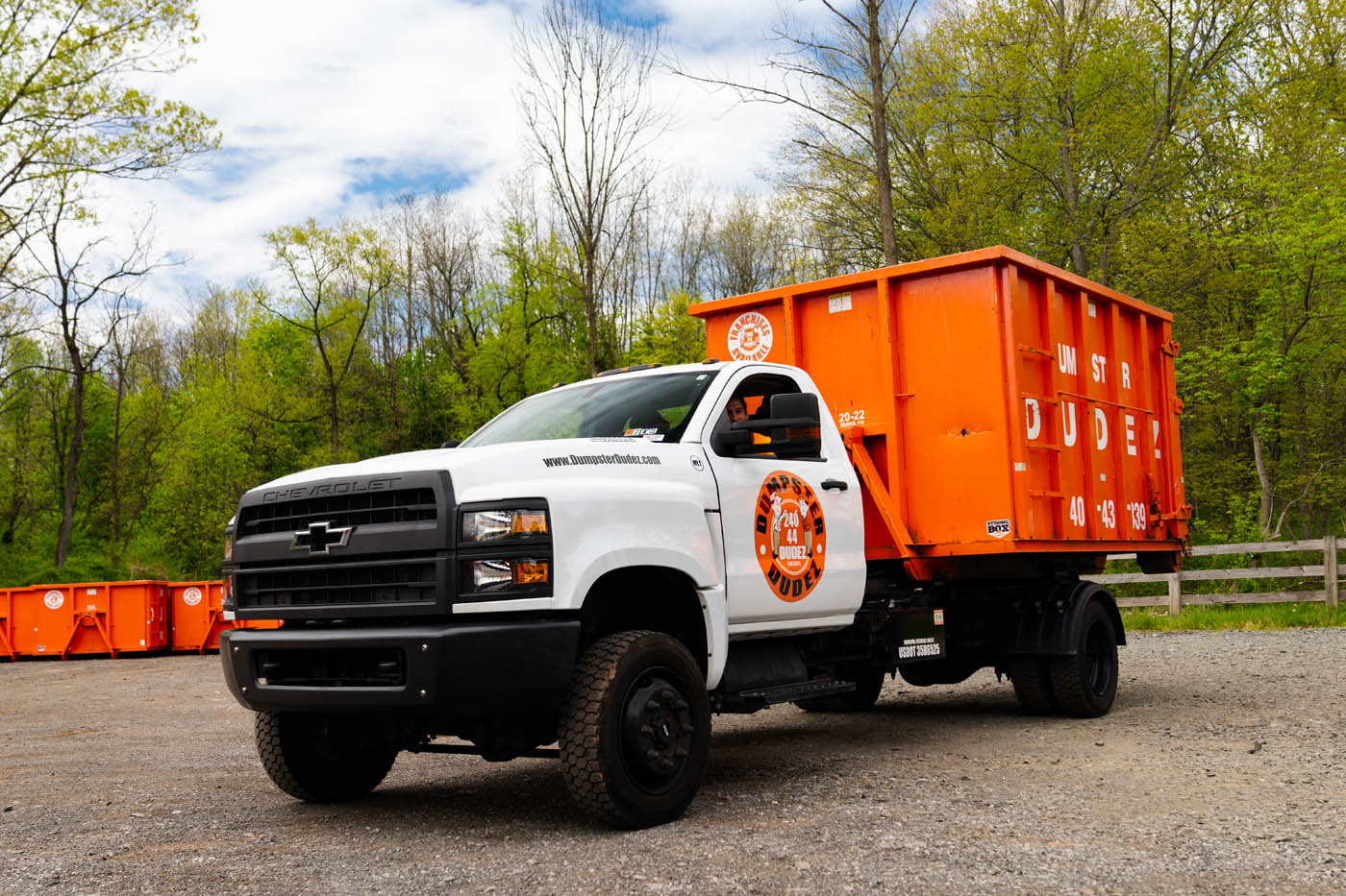 
				A truck with a dumpster ready for a garage cleanout.
			