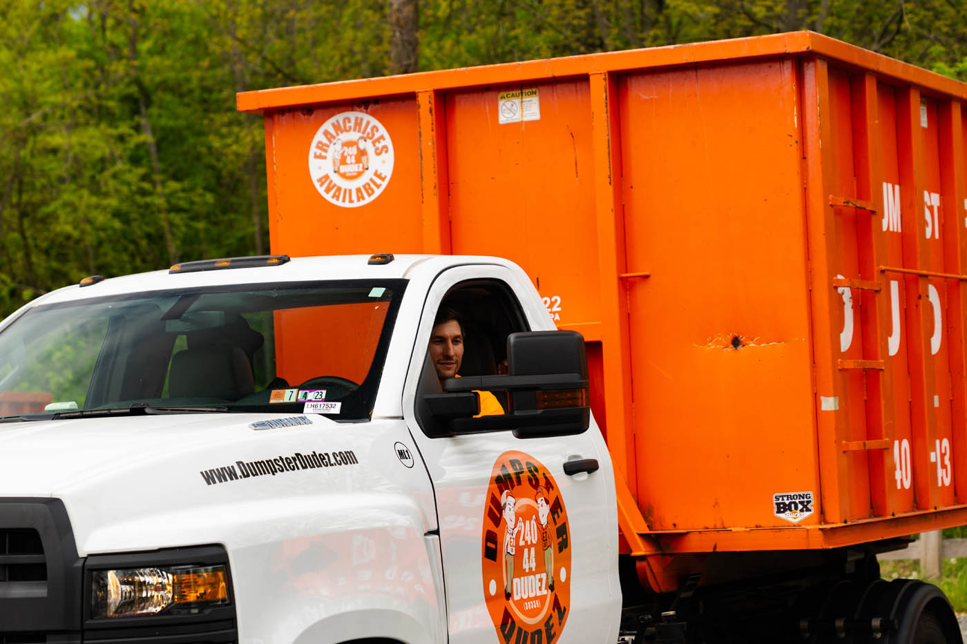 A Dumpster Dudez employee driving a truck to help with furniture removal without injury.