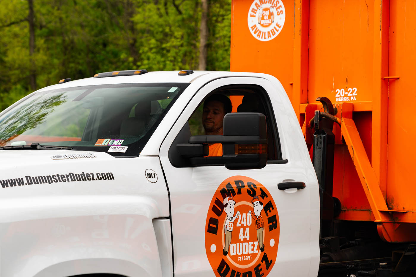 A Dumpster Dudez truck with dumpster on the back - maximize your waste management when you choose us!