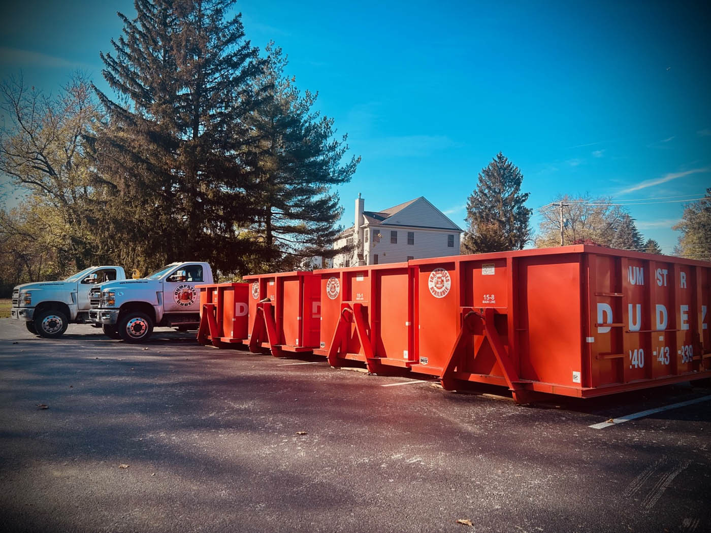 A line of different sized dumpsters from Dumpster Dudez.