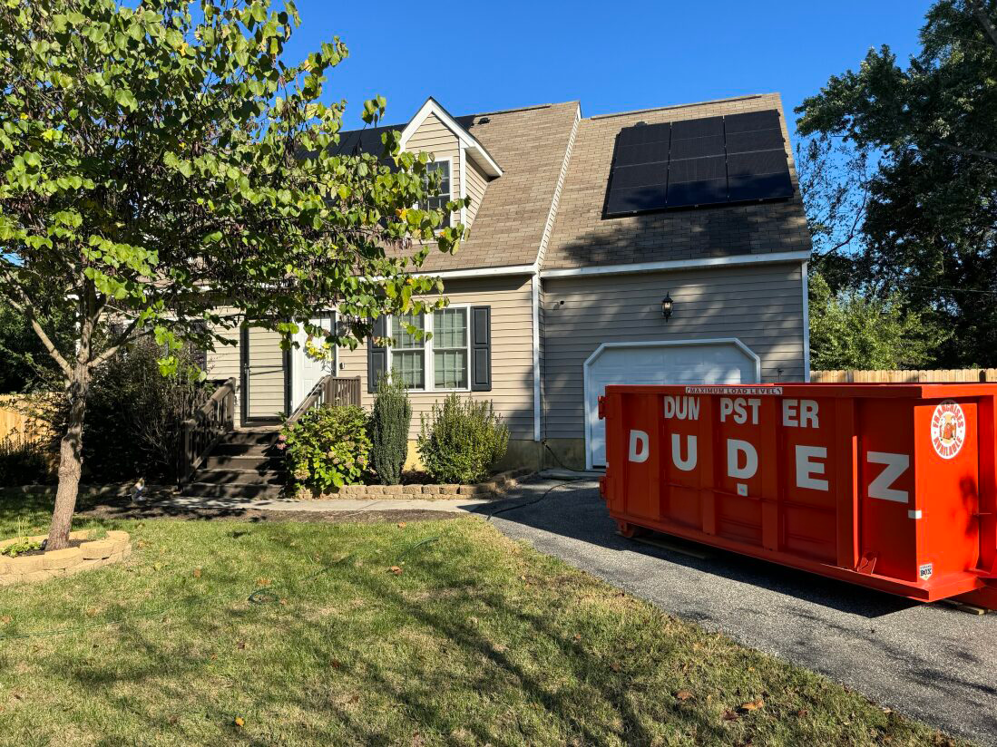 A Dumpster Dudez dumpster rental parked in a driveway, ready to provide waste removal services in Omaha, NE.