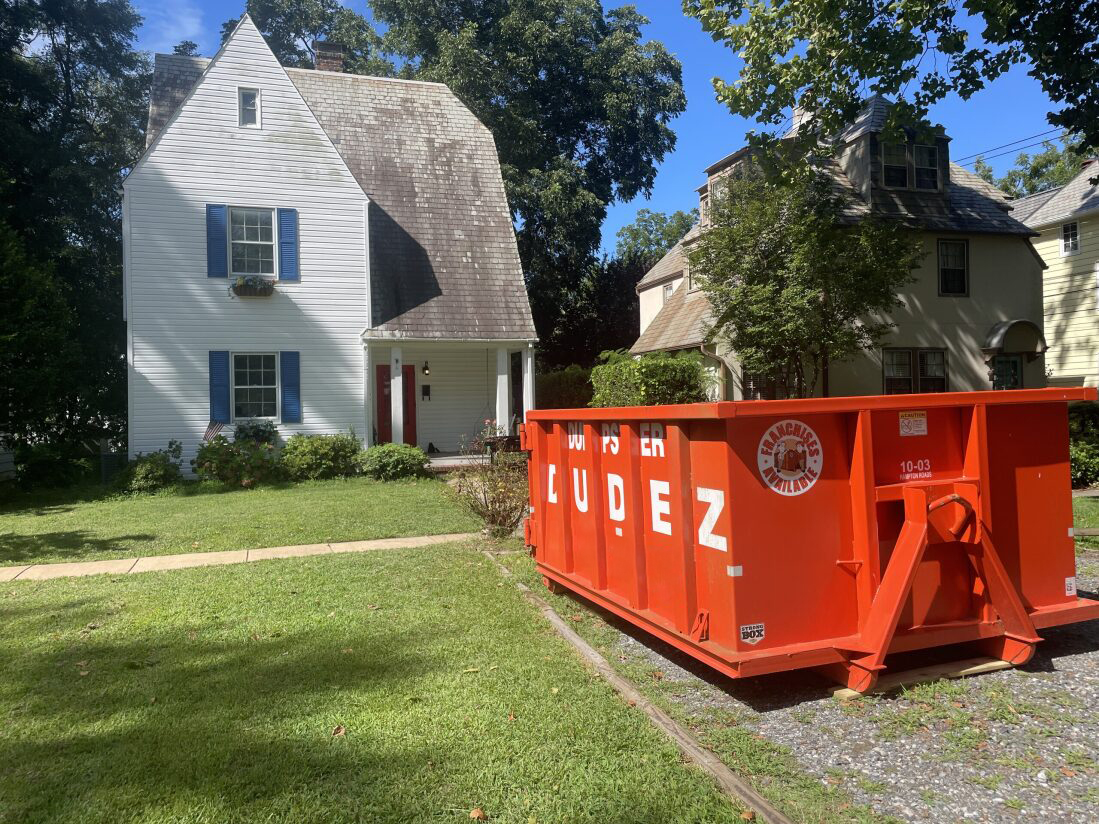 A Dumpster Dudez portable dumpster in Denver, CO being used at a residential property.