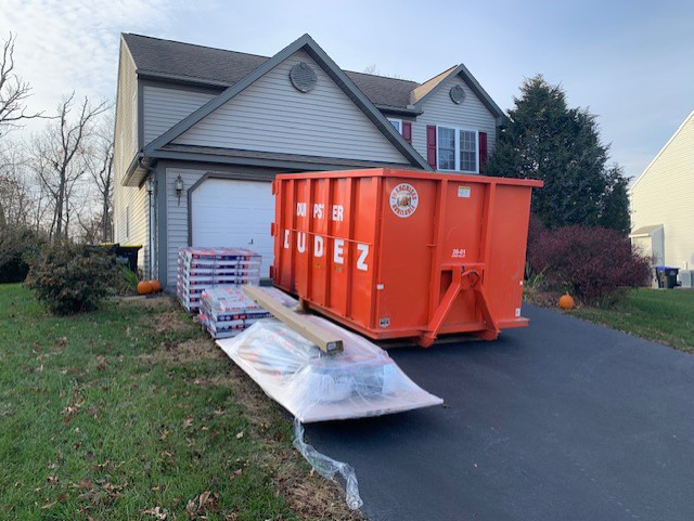 A Dumpster Dudez of Bristol County dumpster parked outside of a home, ready to help with new year clean out projects.